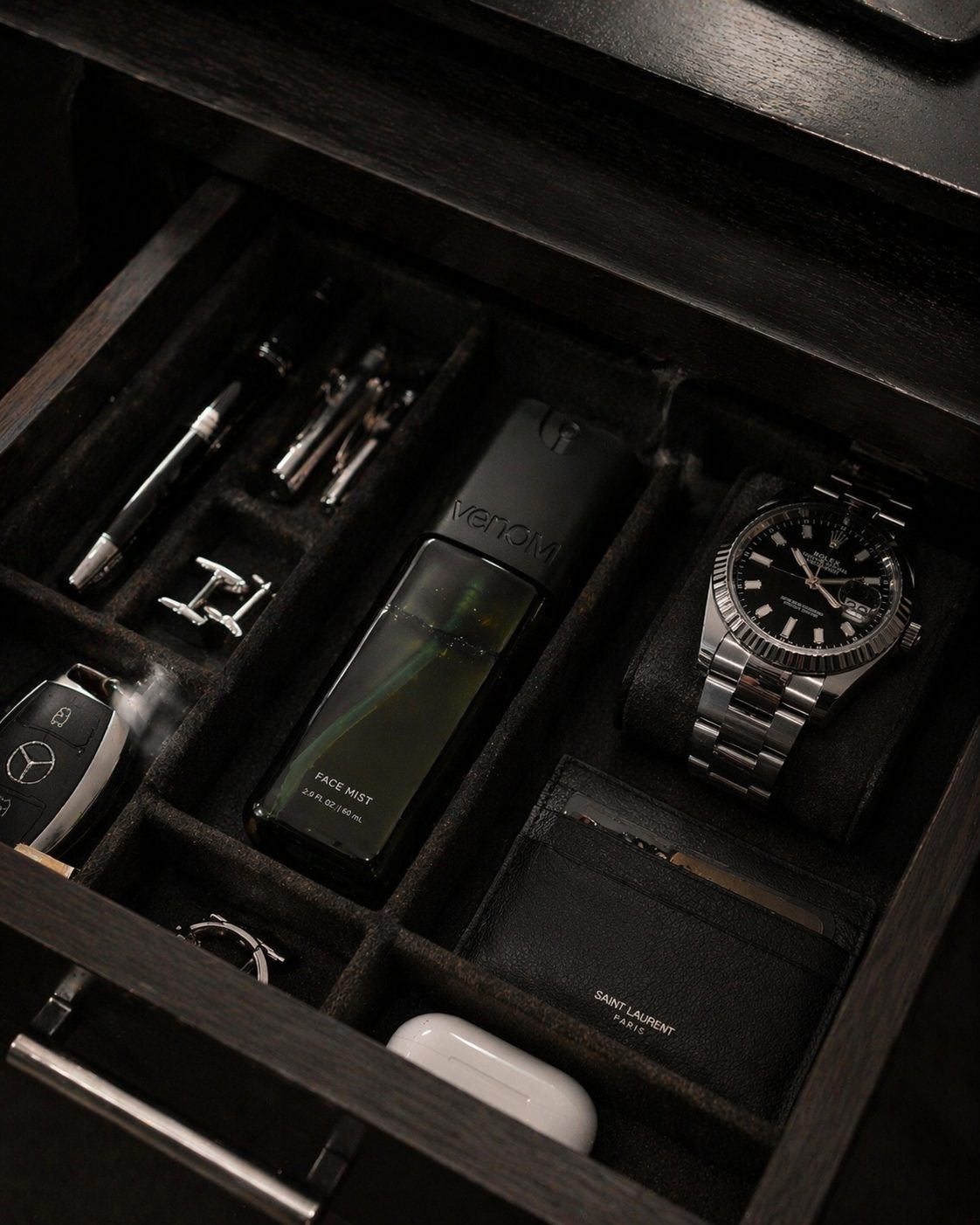 Venom mist alongside a watch and everyday carry