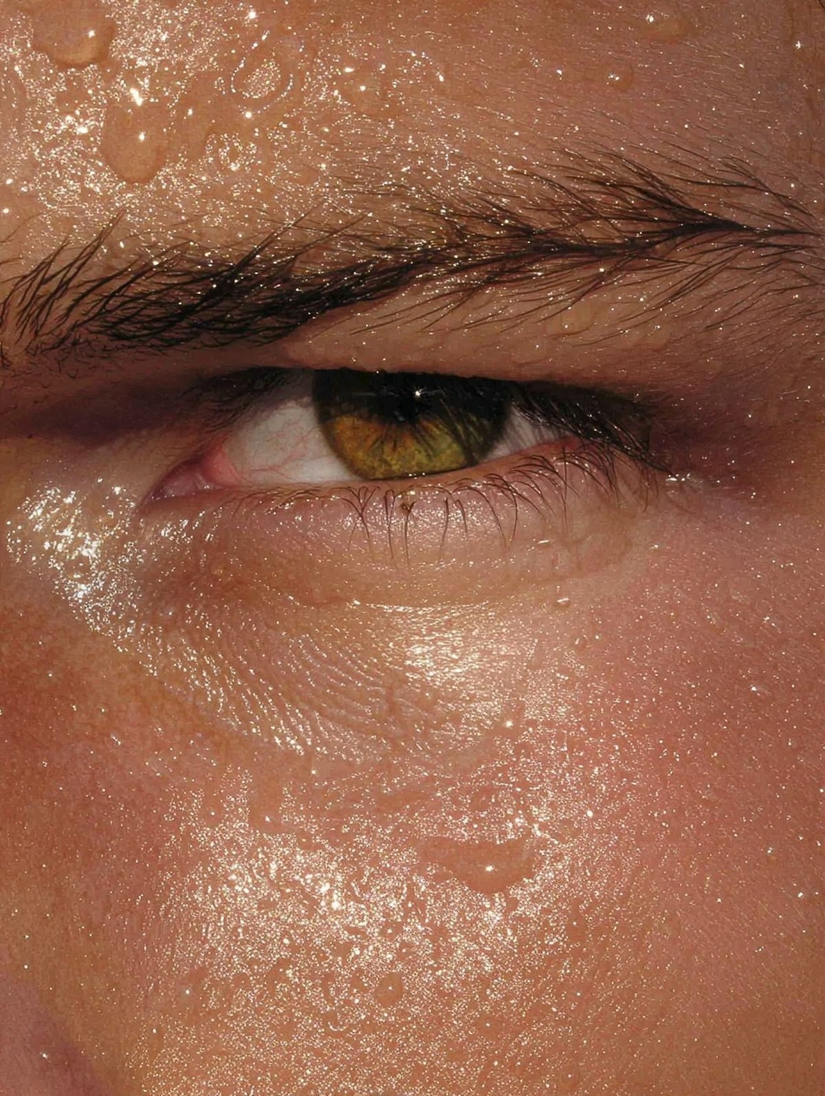 Close-up of a man's eye refreshed with a fine mist